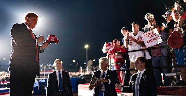 Donald Trump during a Save America Rally, giving autographs to his supporters