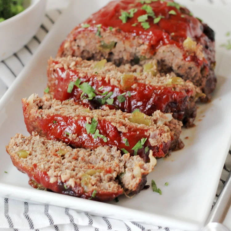 Sliced easy homestyle meatloaf recipe on white serving tray ready to eat