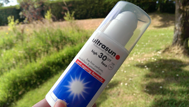 A close up of a bottle of Ultrasun with grass in the background