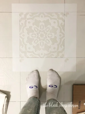 Aligning the stencil with the old tile.