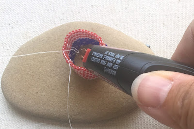 Using a thread burner to cut a thread in beadwork