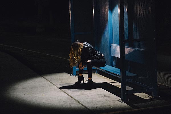 Una mujer sola bajo la luz de un foco.