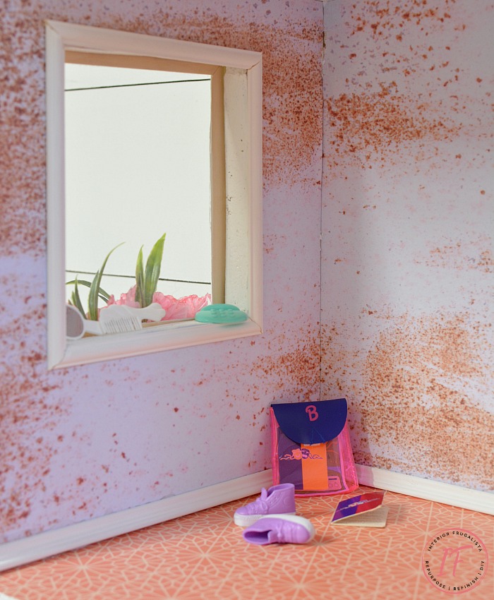 A repurposed IKEA Billy bookcase dollhouse with real wood baseboard trim and decoupage wall coverings in faux brick, plaster, and floral wallpapers.