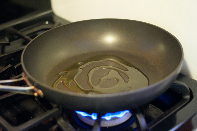 Non-stick frying pay with coconut oil over flame on the stove. 