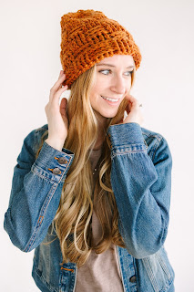 A woman wearing a crochet beanie. The beanie is worked in a basket weave stitch using post crochet stitches.