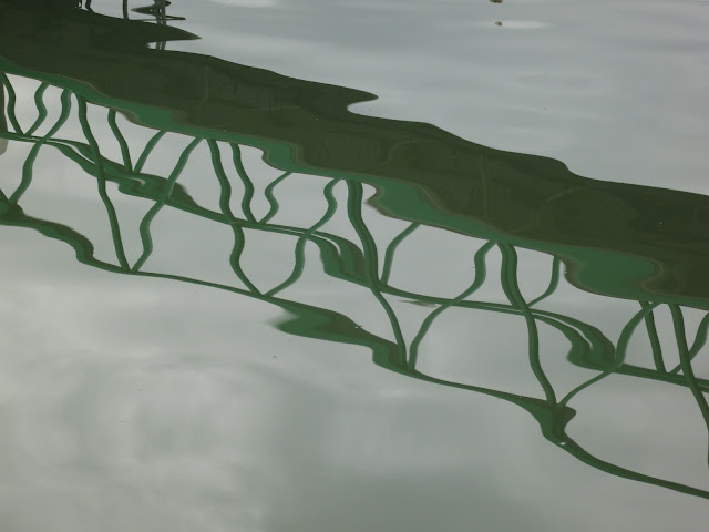 Rippled reflection of footbridge in water