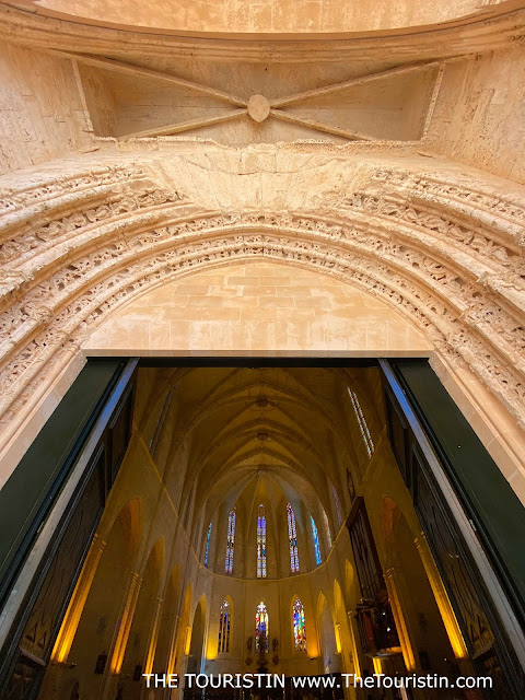 The entrance to a giant sandstone Gothic-style cathedral.