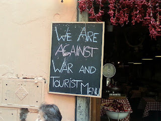 Schild eines Wirts in Trastevere: Gegen Krieg und Tourist-Menu