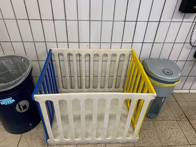 A toddler pen between a dustbin and nappy bin at Colchester Leisure World