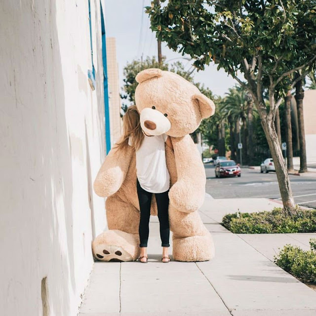 Garota leva seu urso de pelúcia gigante para dar um passeio pela cidade