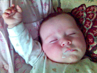 Baby fast asleep, with milk stains around face. 