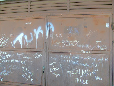 Portão de ferro cheio de nomes escritos em tinta branca. 