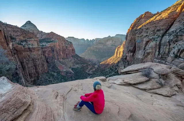 A man sitting on a hill and looking Zion National Park