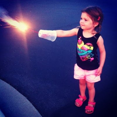 Use a plastic cup to shield sparks from sensitive little arms on 4th of July www.thebrighterwriter.blogspot.com
