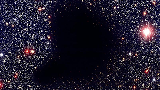 Dark nebula Barnard 68, where stars are not visible in visible light because of a cloud of dust particles. (ESO)