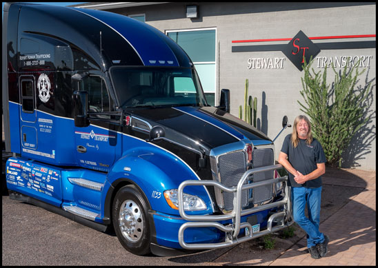 Kelly Lindsey stands with the Stewart Transport Truckers Against Trafficking Everyday Heros 2019 Kenworth T680