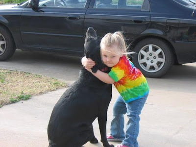 Photo shows child embracing dog