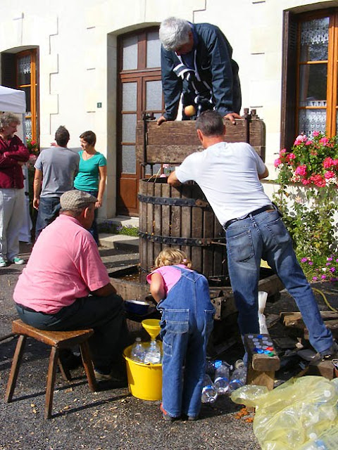 Pressing apples into juice at a village food fair, Indre et Loire, France. Photo by Loire Valley Time Travel.