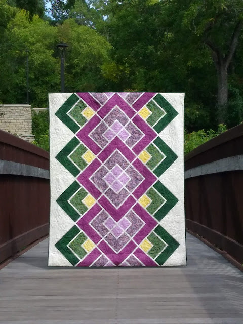 Purple and green geometric quilt on a footbridge