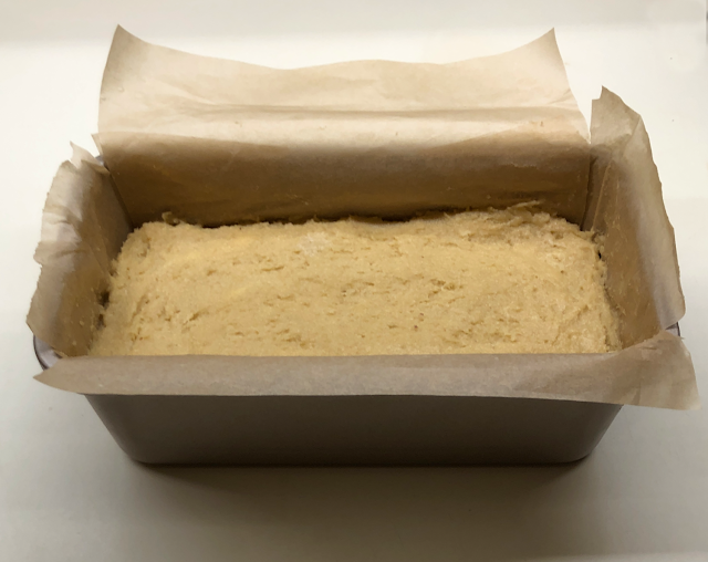 Bread dough in parchment paper lined loaf pan