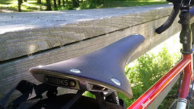 Brooks Cambium Saddle angle view in front of fence