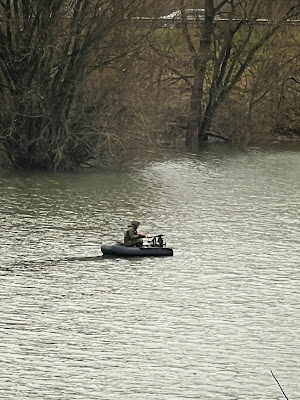 Iemand in klein rubberbootje op de IJssel