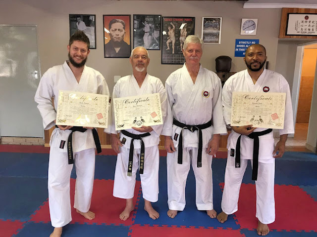 Four karateka receiving certificates