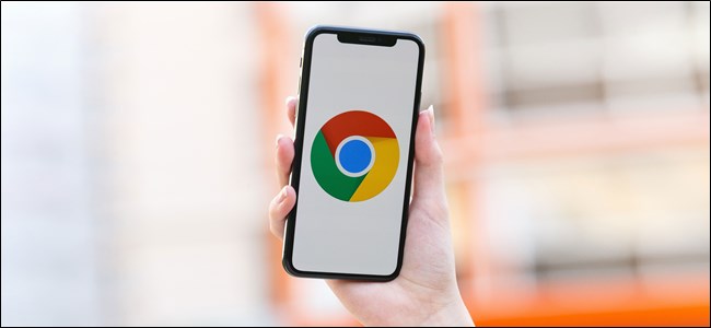 شخص ما يحمل iPhone مع ظهور شعار Chrome على الشاشة.