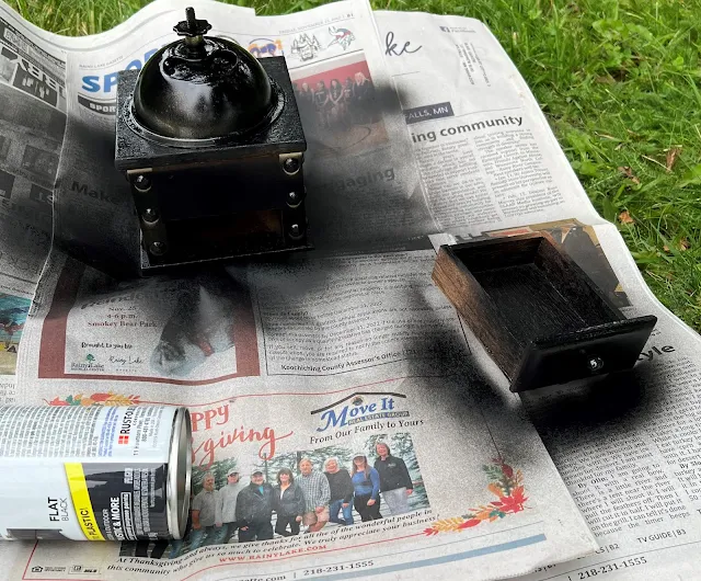 Photo of a coffee grinder being spray painted in flat black.