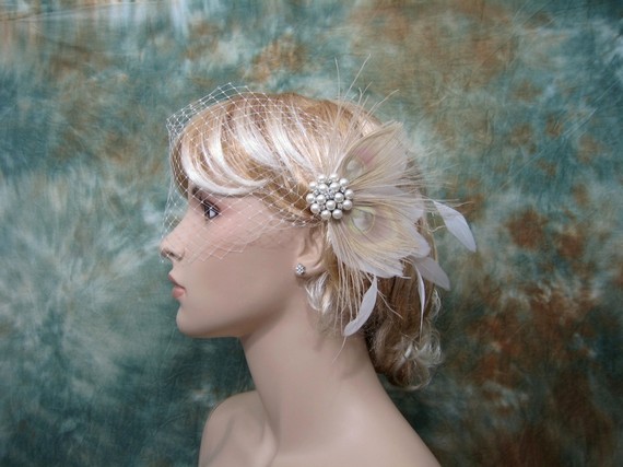 The bleached ivory peacock feathers and pearls in this veil should fit the 