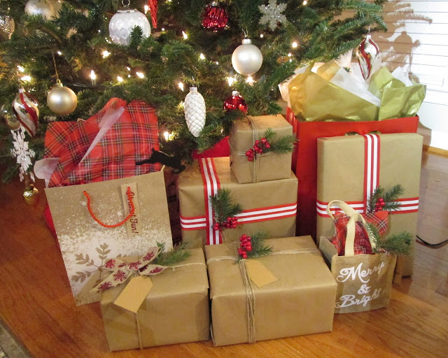 Wrapped Christmas gifts with tree sprigs, striped ribbon, berries, twine and brown paper