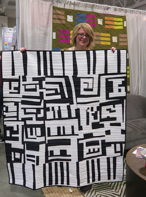 Quiltcon 2019 - Amy and her quilt on Curated Quilts booth