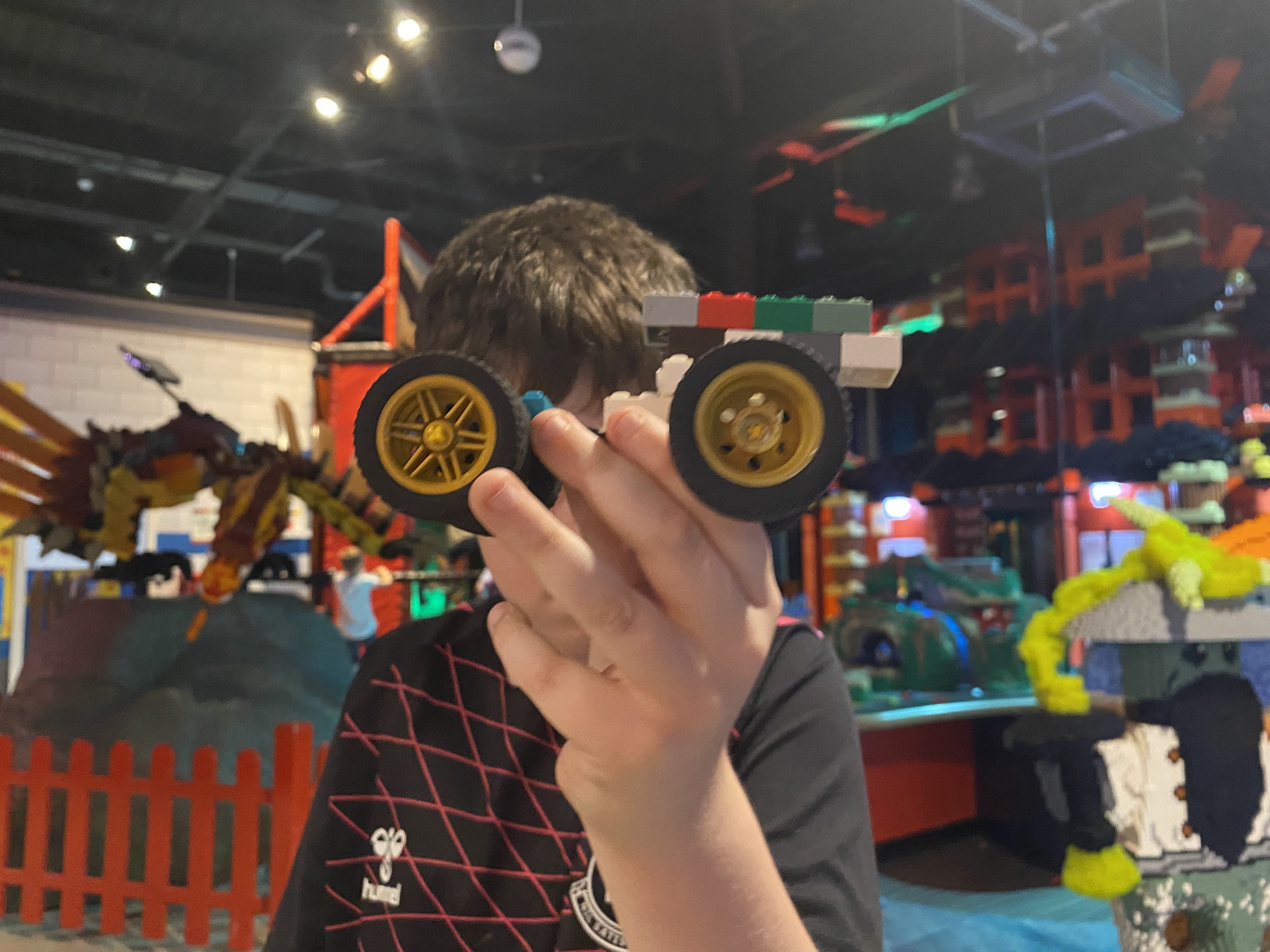 boy holding up a lego car