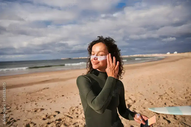 Woman applying sunscreen on cloudy day