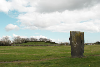 A photo of a standing stone with Huly Hill Cairn in the background.  Photo by Kevin Nosferatu for the Skulferatu Project.
