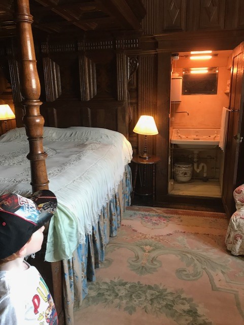 Four poster bedroom with an open wardrode which is housing a sink