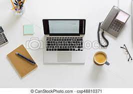 Online reputation management desk with a computer, notepad and pencil, telephone handset, calculator, eye glasses, a mug of coffee and a glass mug pencils holder.