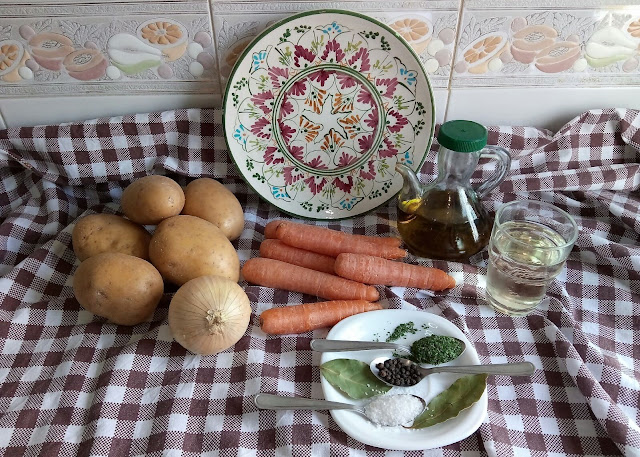 Imagen con los ingredientes para 4 personas de patatas a lo pobre para cuatro personas; cebollas aceite, patatas, zanahoria, ajo, perejil
