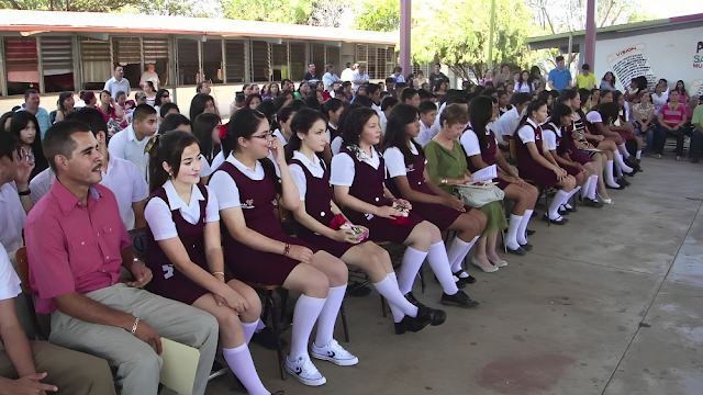La imagen muestra a un grupo de personas sentadas juntas. El grupo está formado por escolares mexicanas de secundaria.