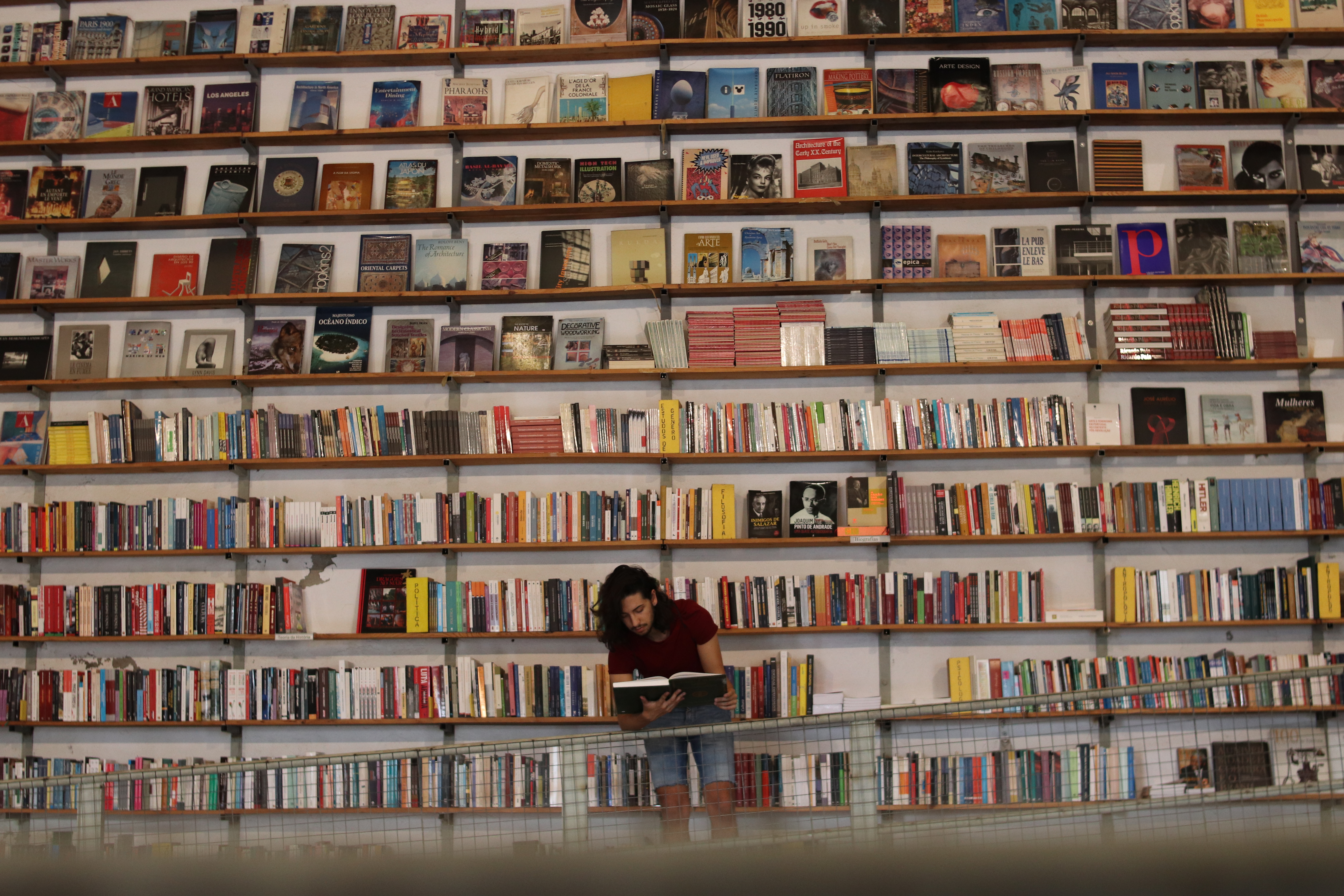 Man sitting in front of ton of books reading