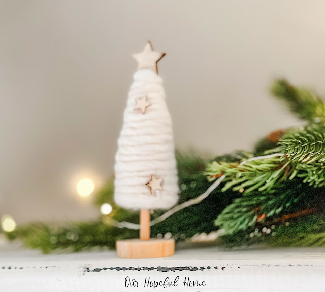 yarn-wrapped Christmas tree on wood pedestal and winkle lights