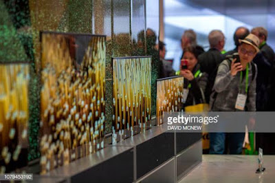 People look at the LG Signature OLED TV R at a display in LG exhibit  during CES 2019
