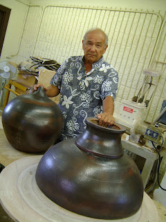 Kauai CC professor Wayne Miyata stands holding sacred ball sections created for Hall of Compassion