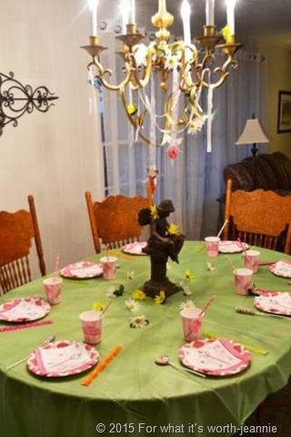 childrens fairy party table with pink settings on green cloth