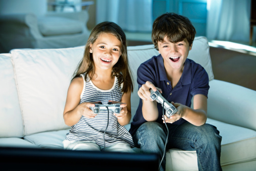 Two children playing video game on computer
