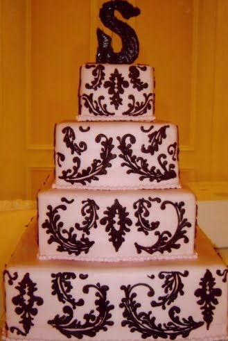 White cake with pale pink ribbon pink roses and black and white damask 