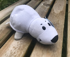 white seal plush toy on a bench in garden 