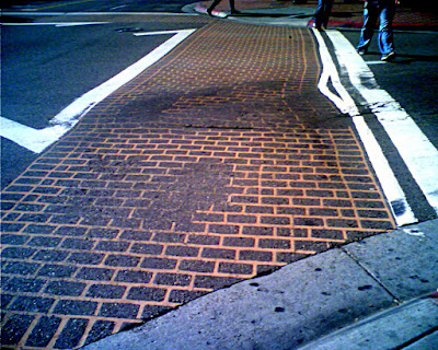 Picture of Brick effect crosswalk at the intersection of Fifth and Market.  The fake bricks have partially worn off.