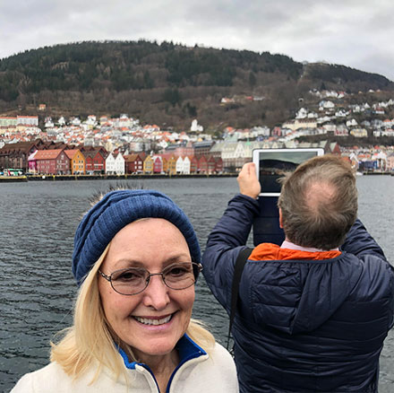 Resident Astronomer Peggy poses with iconic Bergen houses in the background (Source: Palmia Observatory)