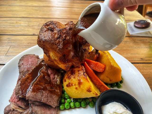 roast beef with roasted vegetables, Yorkshire pudding, horseradish sauce, and gravy